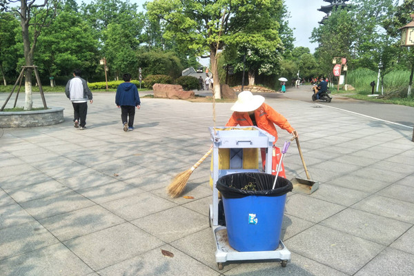 志愿者协助清洁人员清扫垃圾